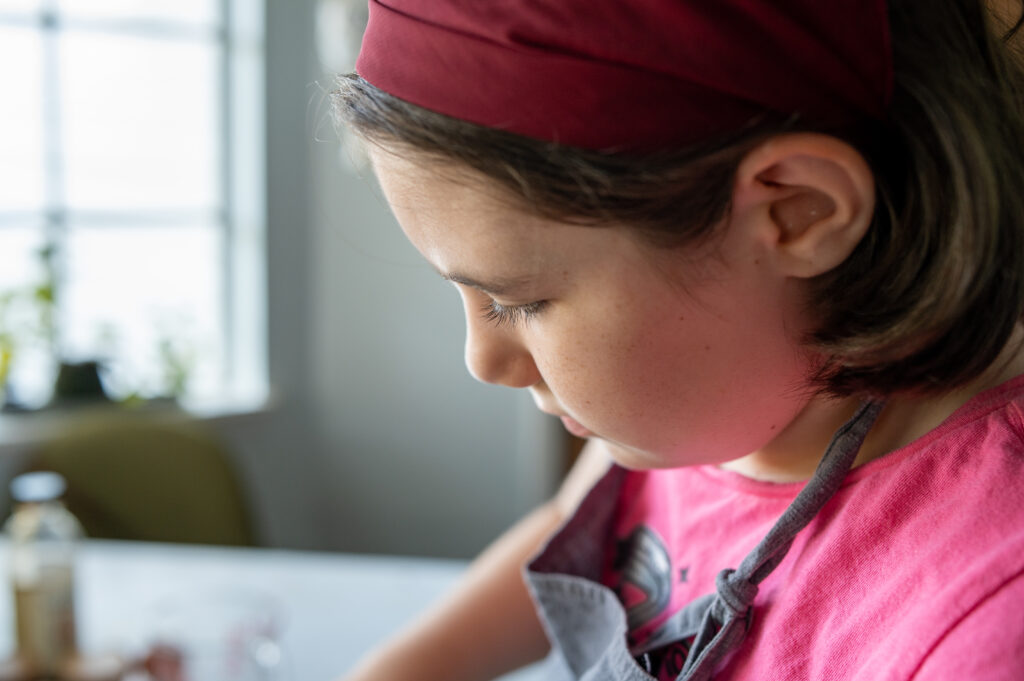 child baking, wearing a red bandana